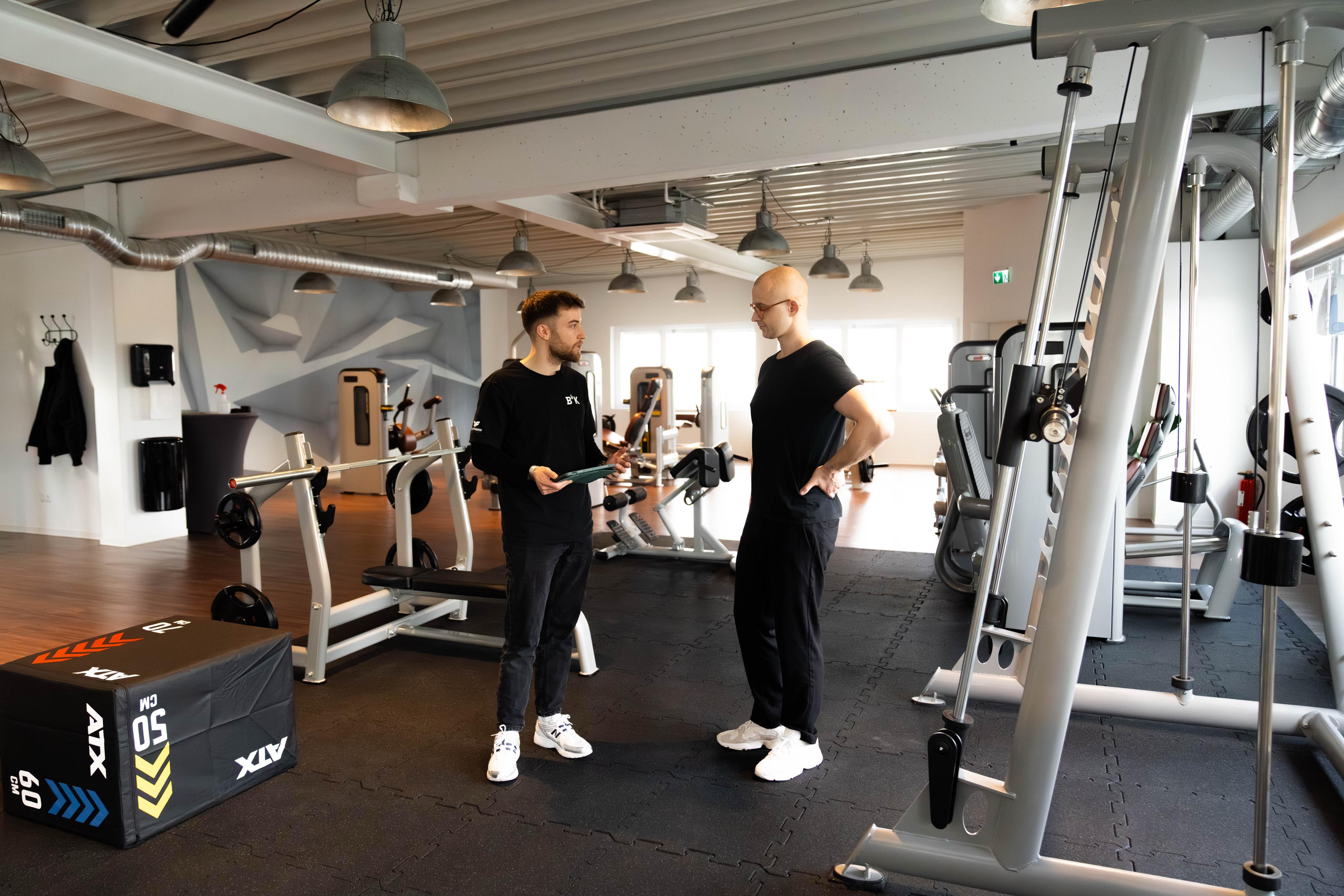 Trainer und Klient im Gespräch auf der Trainingsfläche