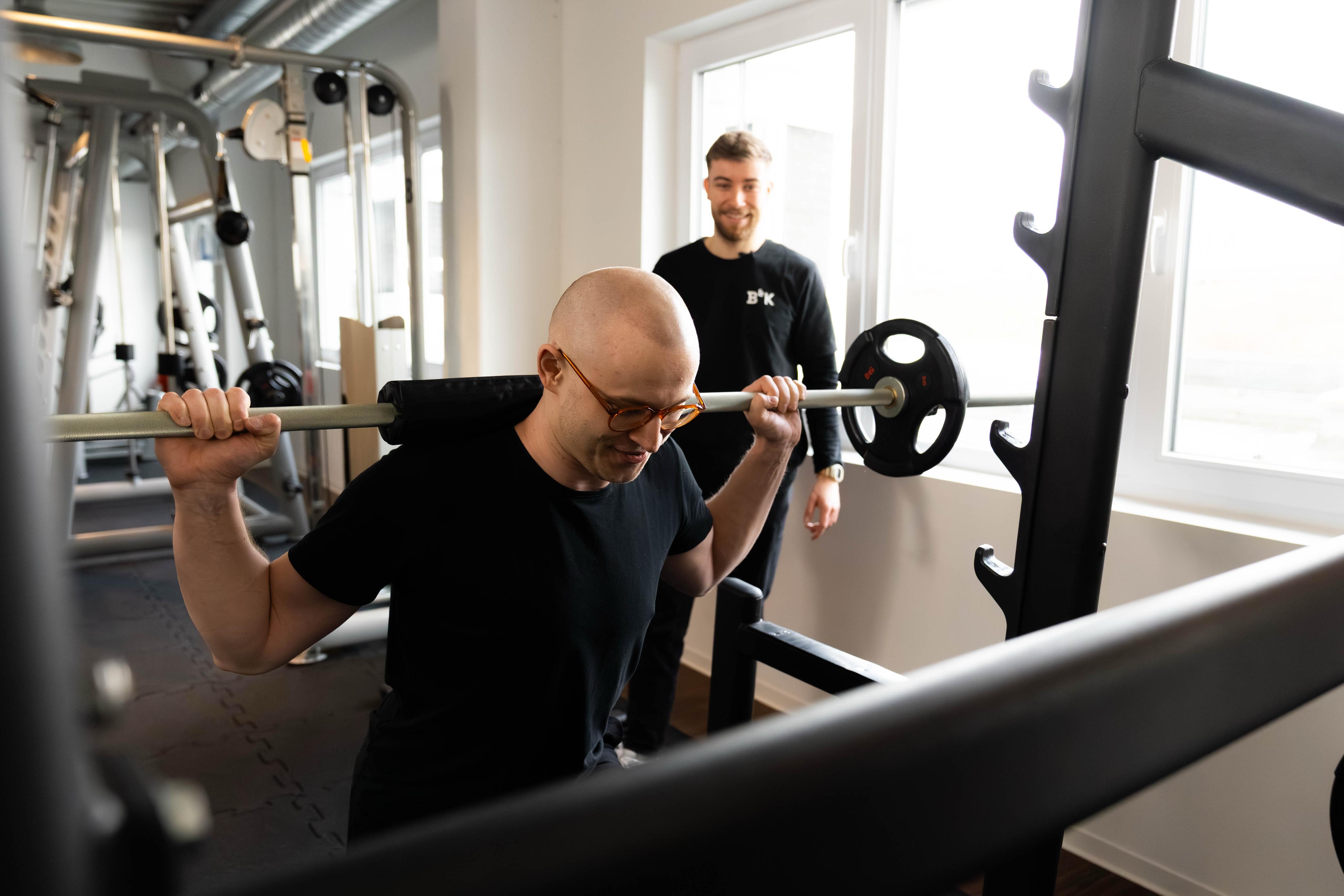 Kniebeuge mit Langhantel, Trainer korrigiert