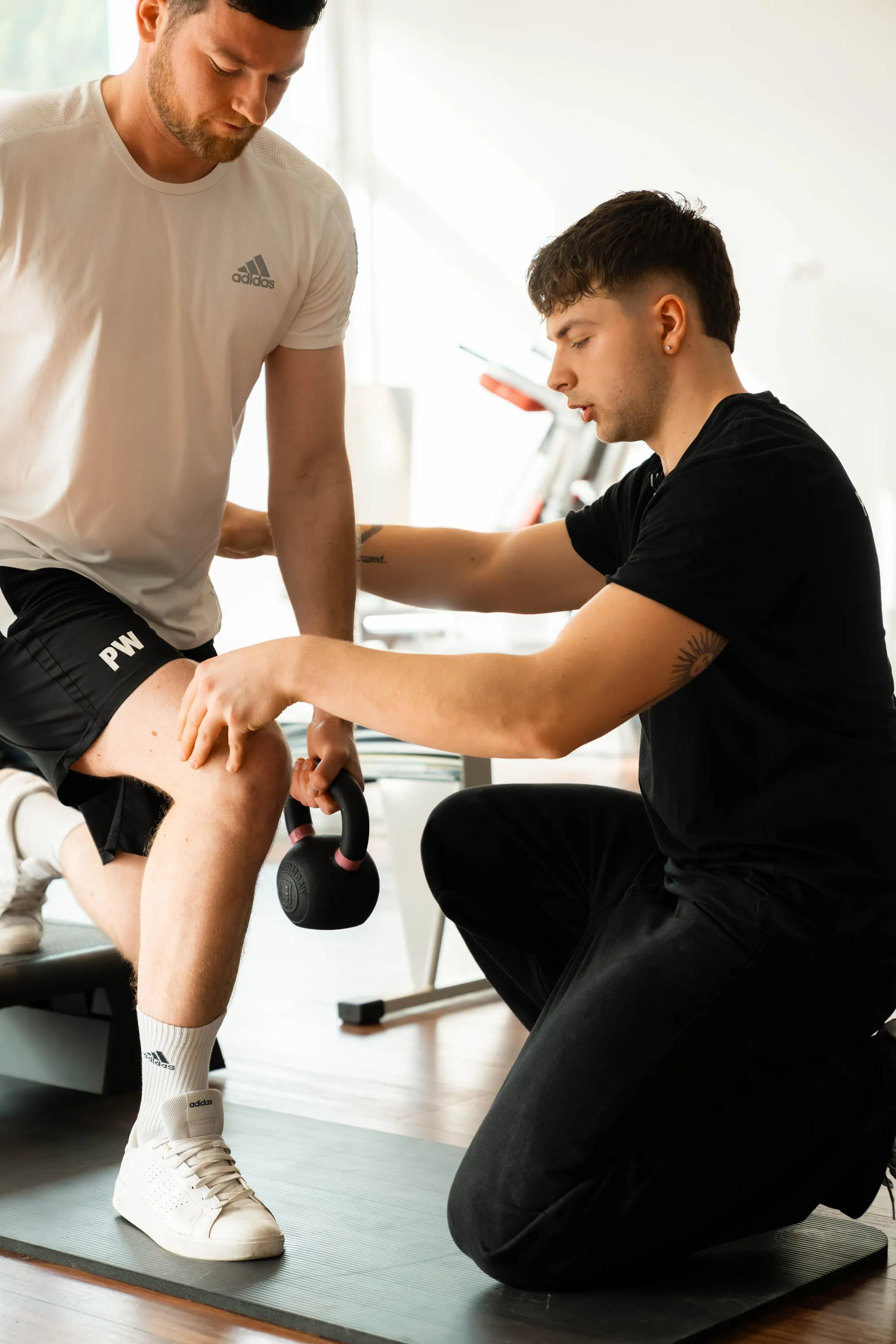 Trainer korrigiert die Technik beim Kettlebell-Training