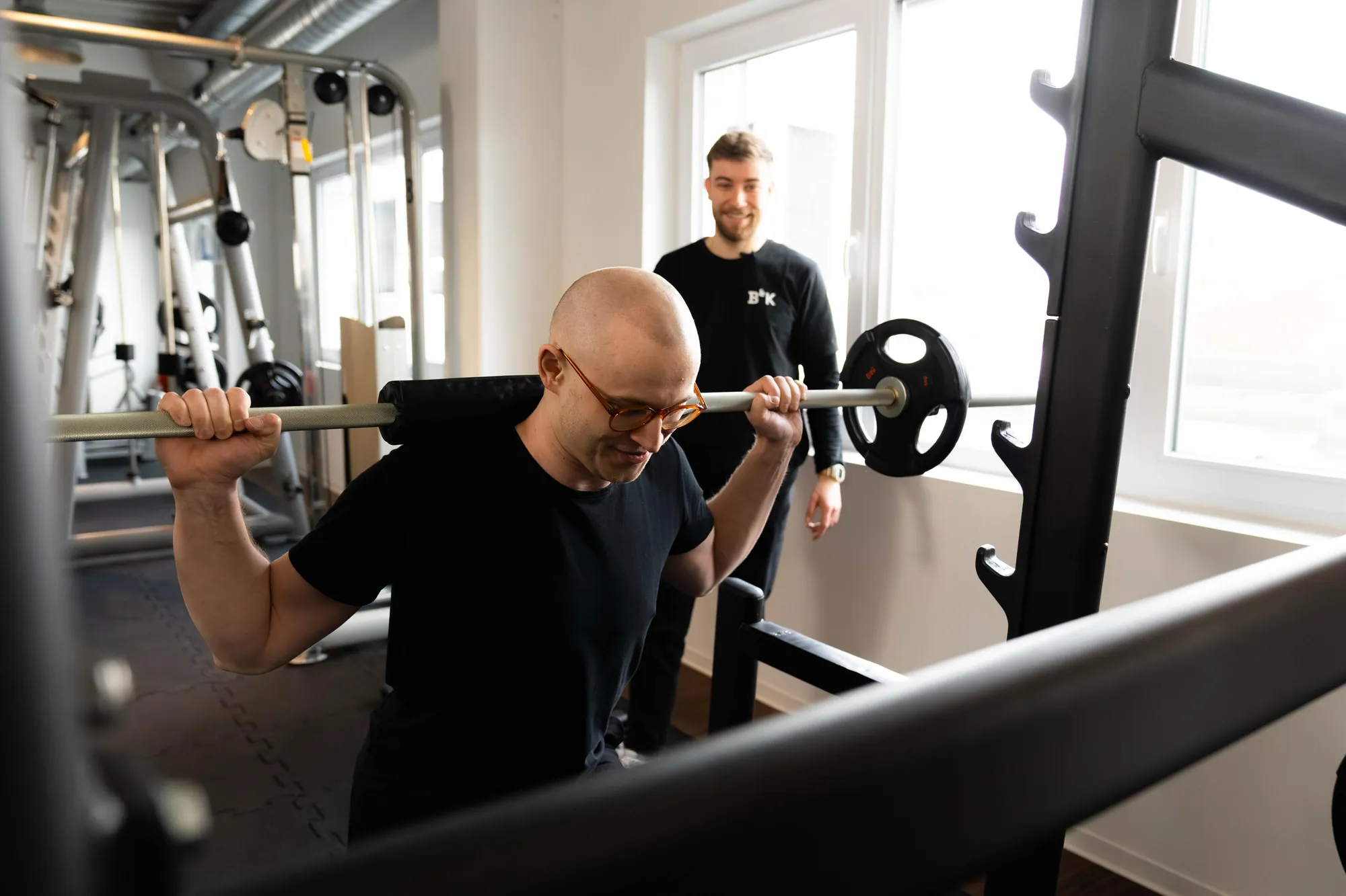 Kniebeuge mit Langhantel, Trainer korrigiert