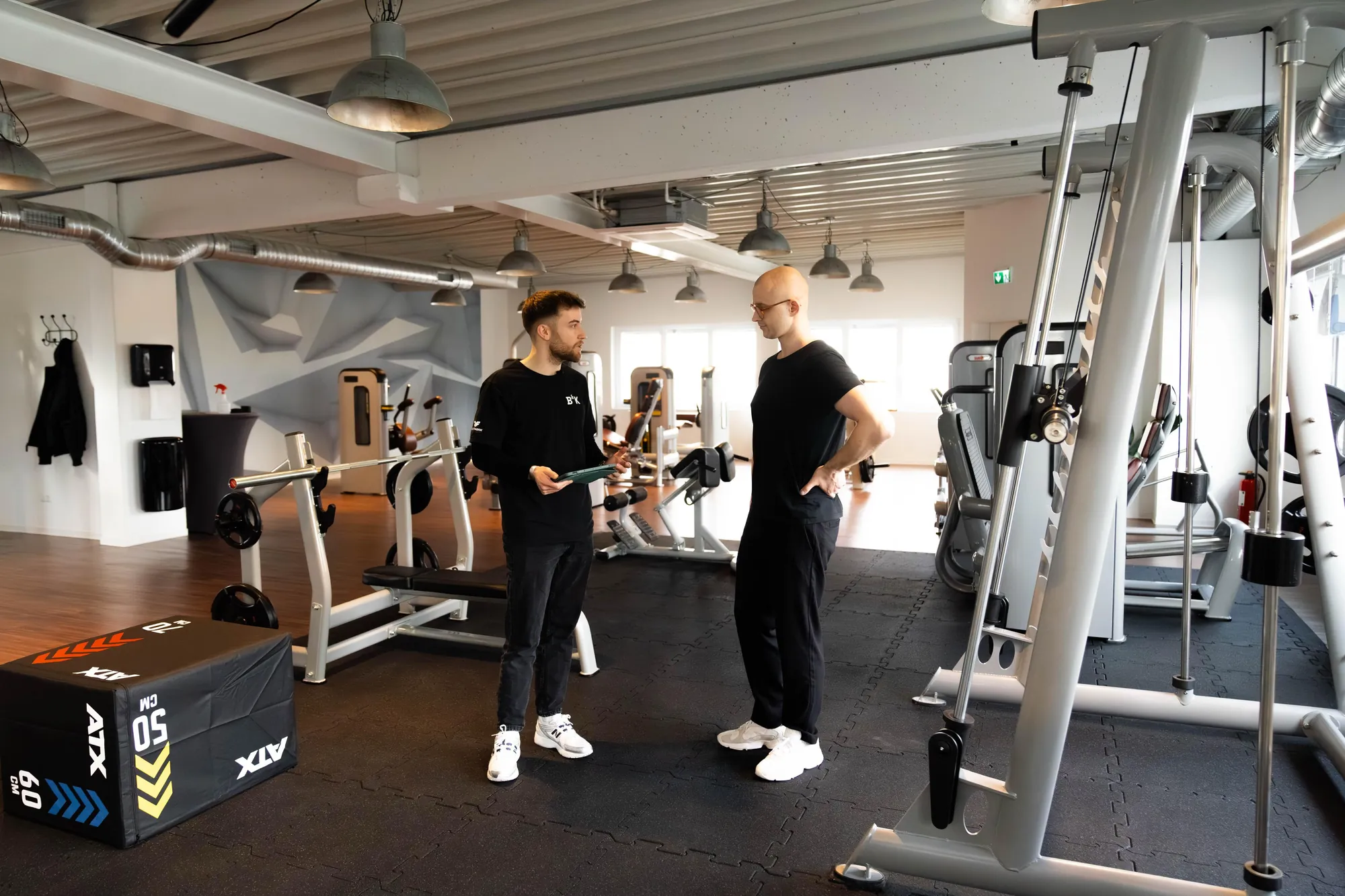 Trainer und Klient im Gespräch auf der Trainingsfläche